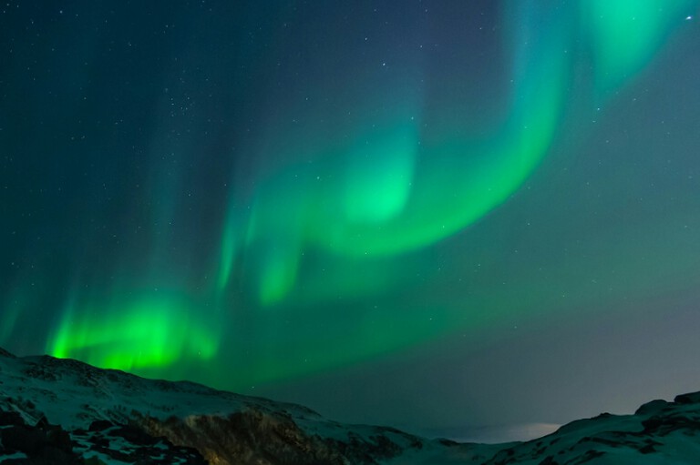 Northern lights over snowy mountain
